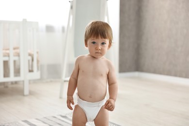 Photo of Cute little child in diaper at home