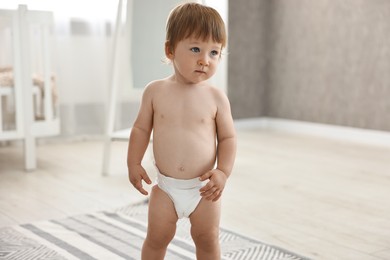 Cute little child in diaper at home