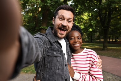 Photo of International relationships. Lovely couple taking selfie outdoors