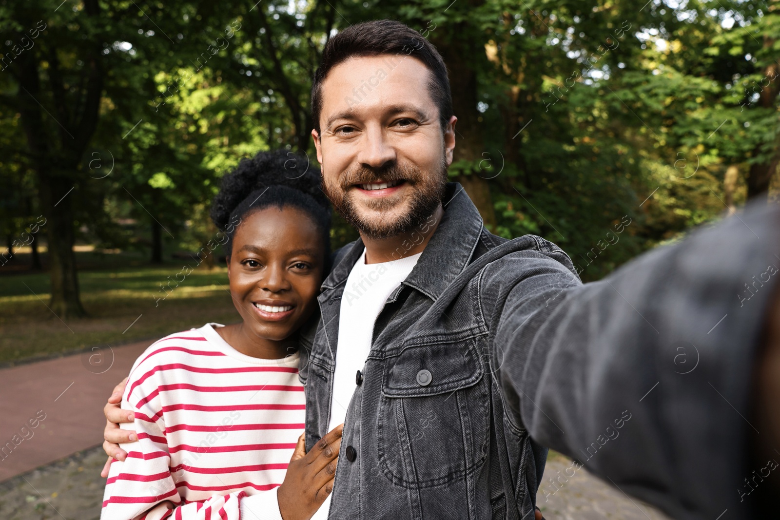 Photo of International relationships. Lovely couple taking selfie outdoors