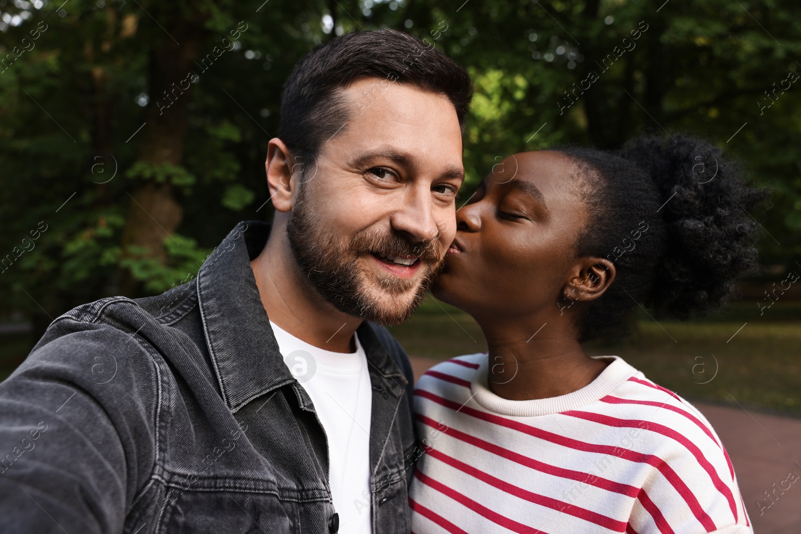 Photo of International relationships. Lovely couple taking selfie outdoors