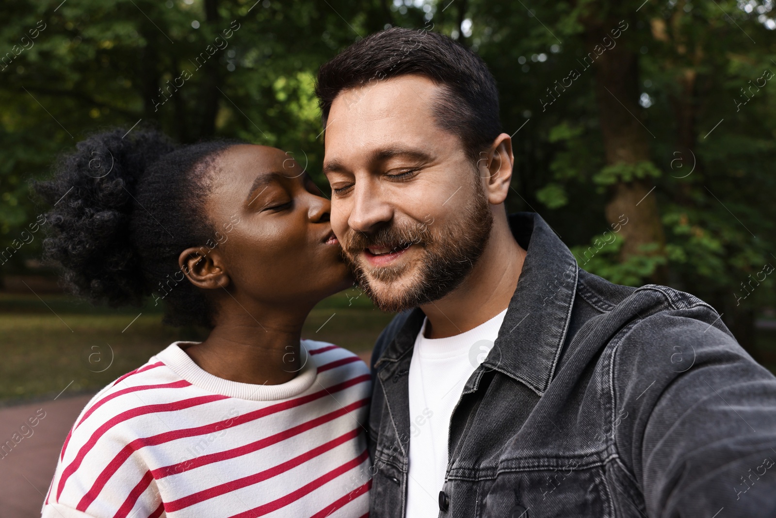 Photo of International relationships. Lovely couple taking selfie outdoors