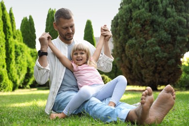 Father and his daughter spending time together on green lawn in park