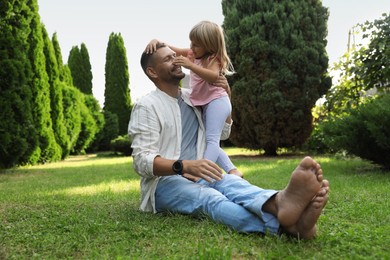 Photo of Father and his daughter spending time together on green lawn in park