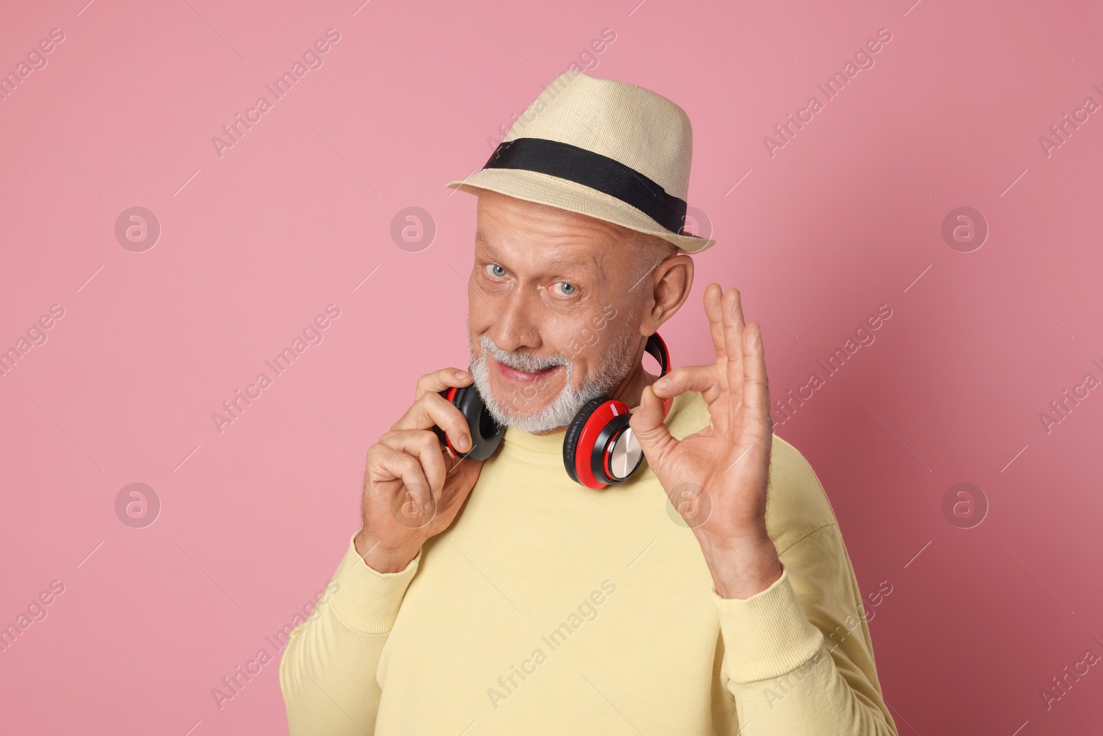 Photo of Portrait of handsome senior man showing ok gesture on pink background