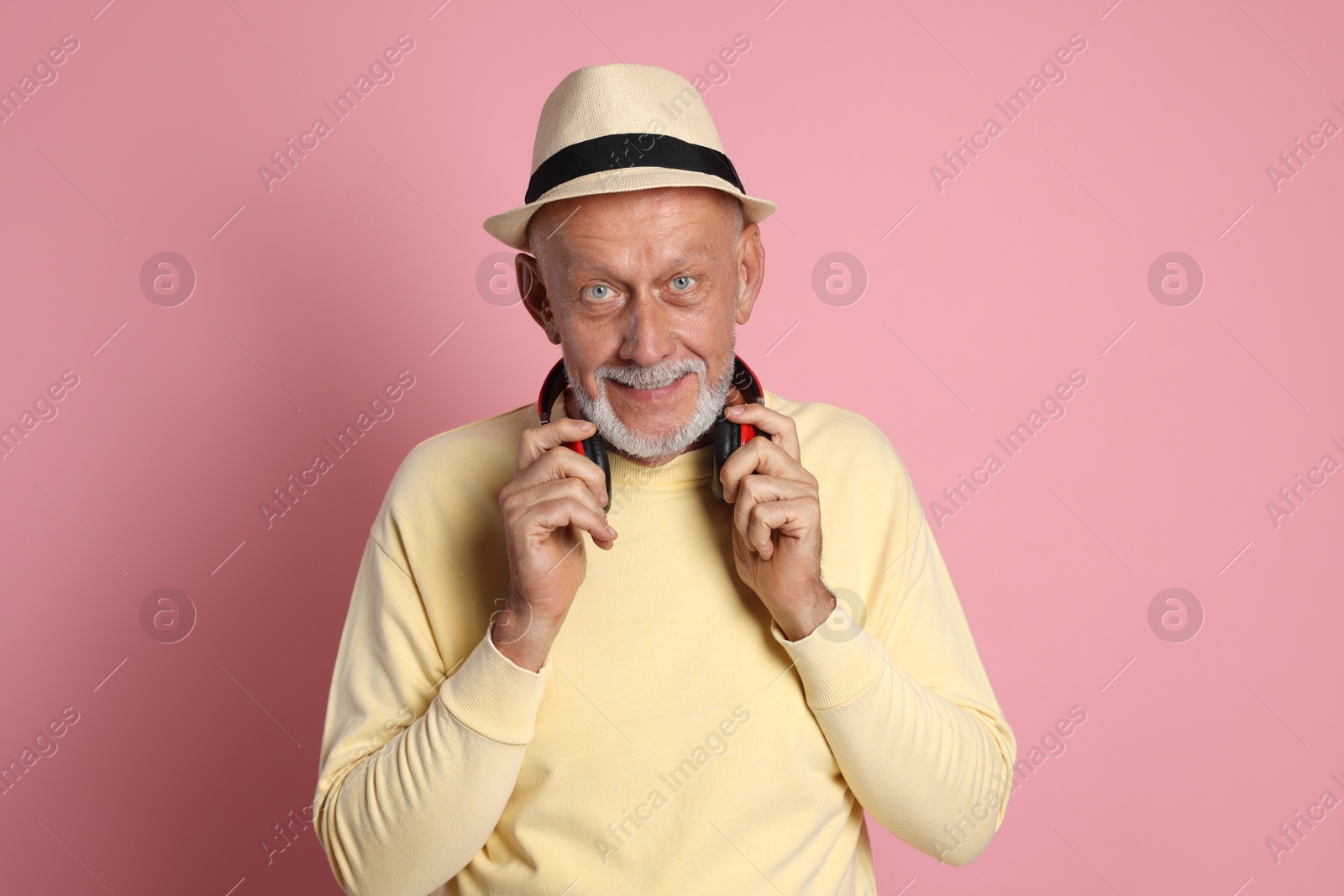 Photo of Portrait of handsome senior man with headphones on pink background