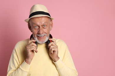 Photo of Portrait of handsome senior man with headphones on pink background. Space for text