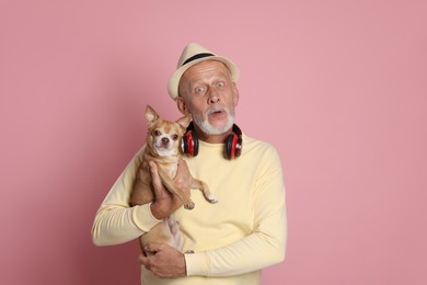 Photo of Portrait of surprised senior man with Chihuahua dog on pink background