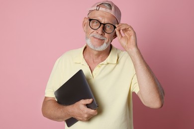 Photo of Portrait of handsome senior man with laptop on pink background