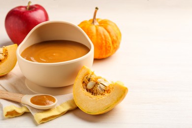 Photo of Delicious baby food in bowl and fresh ingredients on white wooden table, space for text