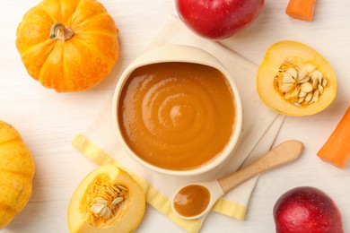 Photo of Delicious baby food in bowl and fresh ingredients on white wooden table, flat lay