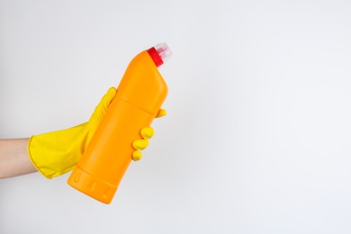 Photo of Woman holding toilet cleaner in bottle on light background, closeup. Space for text