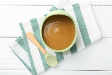 Photo of Delicious baby food in bowl on white wooden table, top view