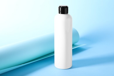 Photo of Shampoo in bottle on light blue background. Personal care product