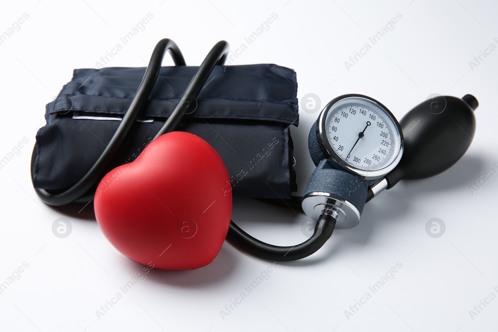 Photo of Blood pressure measuring device and red decorative heart on light background