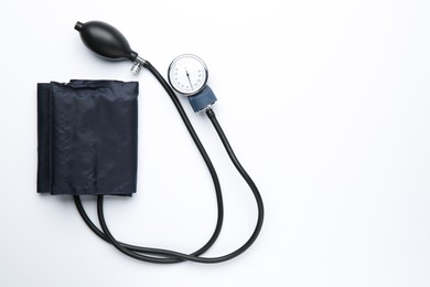 Photo of Blood pressure measuring device on light background, top view. Space for text