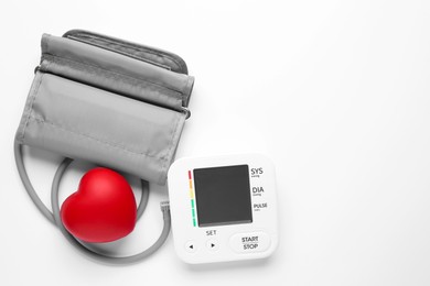 Photo of Blood pressure measuring device and squeeze heart on white background, top view. Space for text