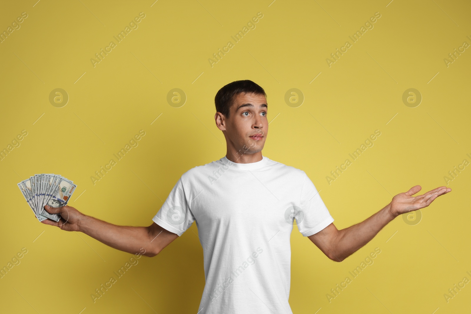 Photo of Man with dollar banknotes on yellow background