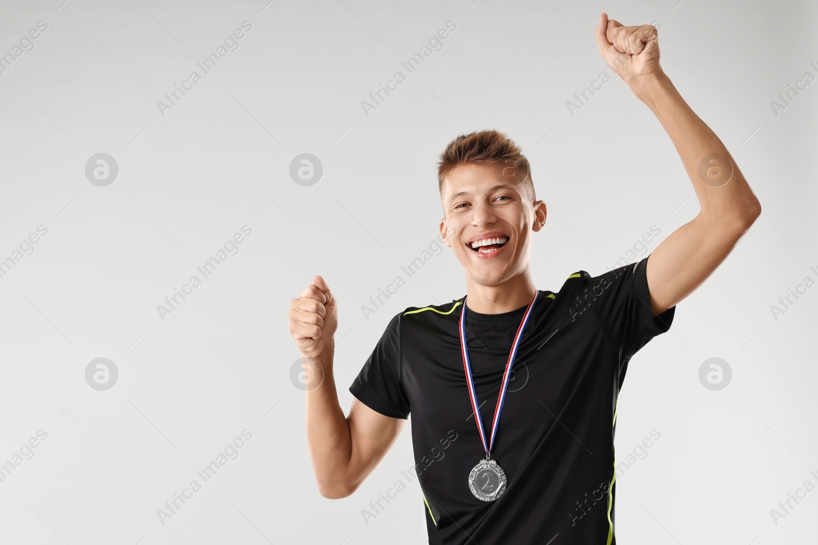 Photo of Happy winner with silver medal on light grey background. Space for text