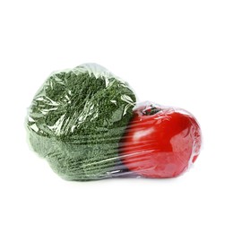 Green broccoli and tomato with plastic food wrap isolated on white