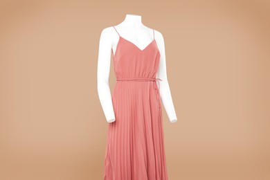 Photo of Female mannequin with stylish dress on light brown background