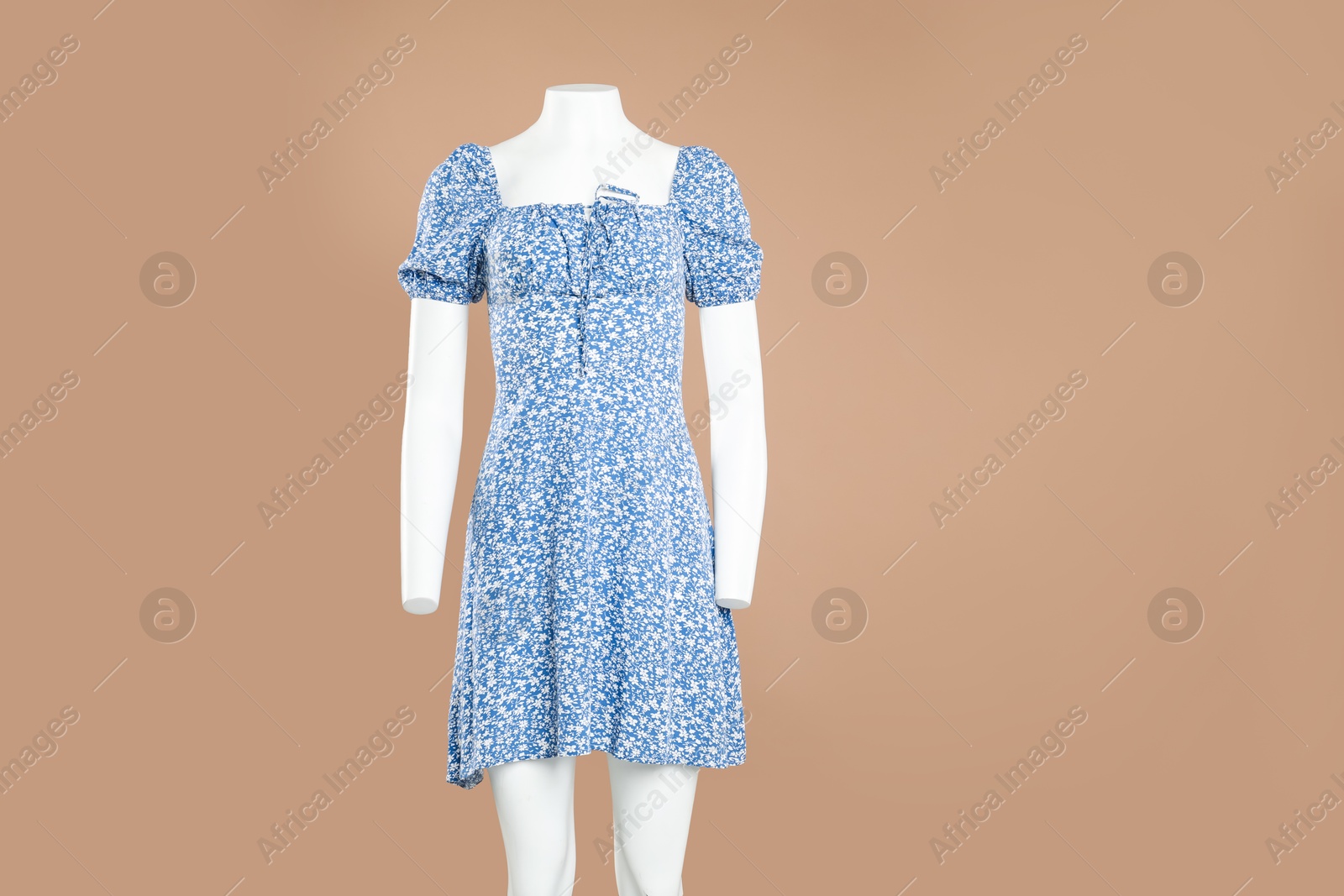 Photo of Female mannequin with stylish dress on light brown background, space for text