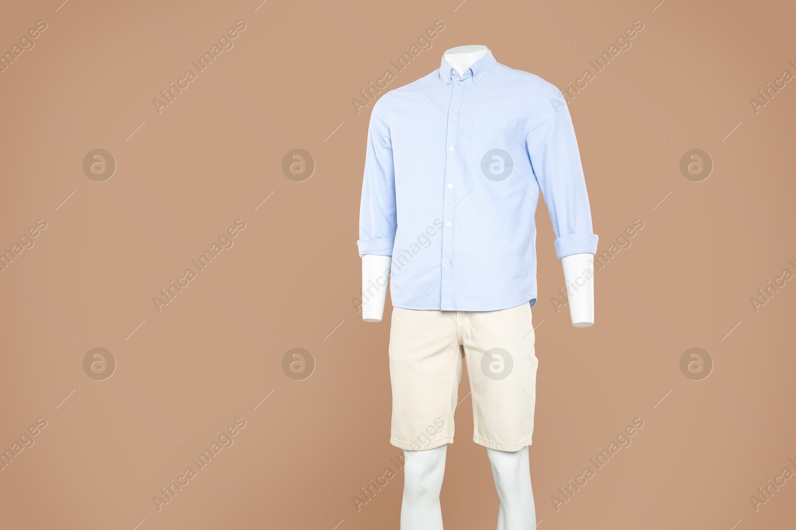 Photo of Male mannequin with stylish outfit on light brown background, space for text