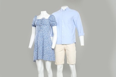 Photo of Female and male mannequins with stylish outfits on light grey background