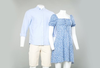 Photo of Female and male mannequins with stylish outfits on light grey background