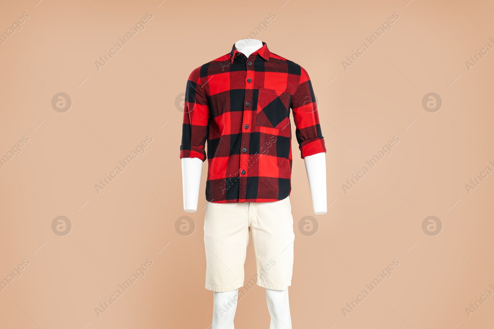 Photo of Male mannequin with stylish outfit on light brown background