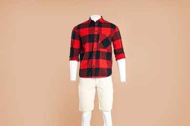 Photo of Male mannequin with stylish outfit on light brown background