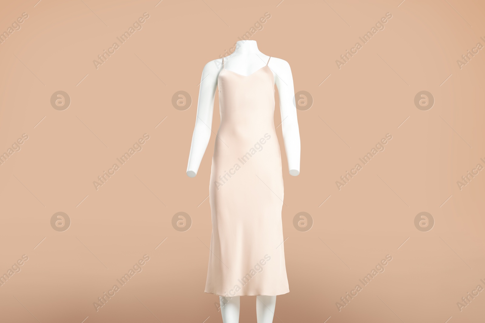 Photo of Female mannequin with stylish dress on light brown background