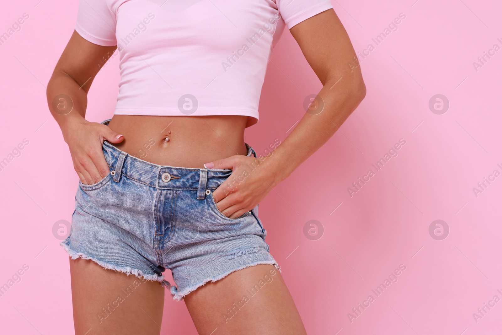 Photo of Woman wearing stylish denim shorts on pink background, closeup