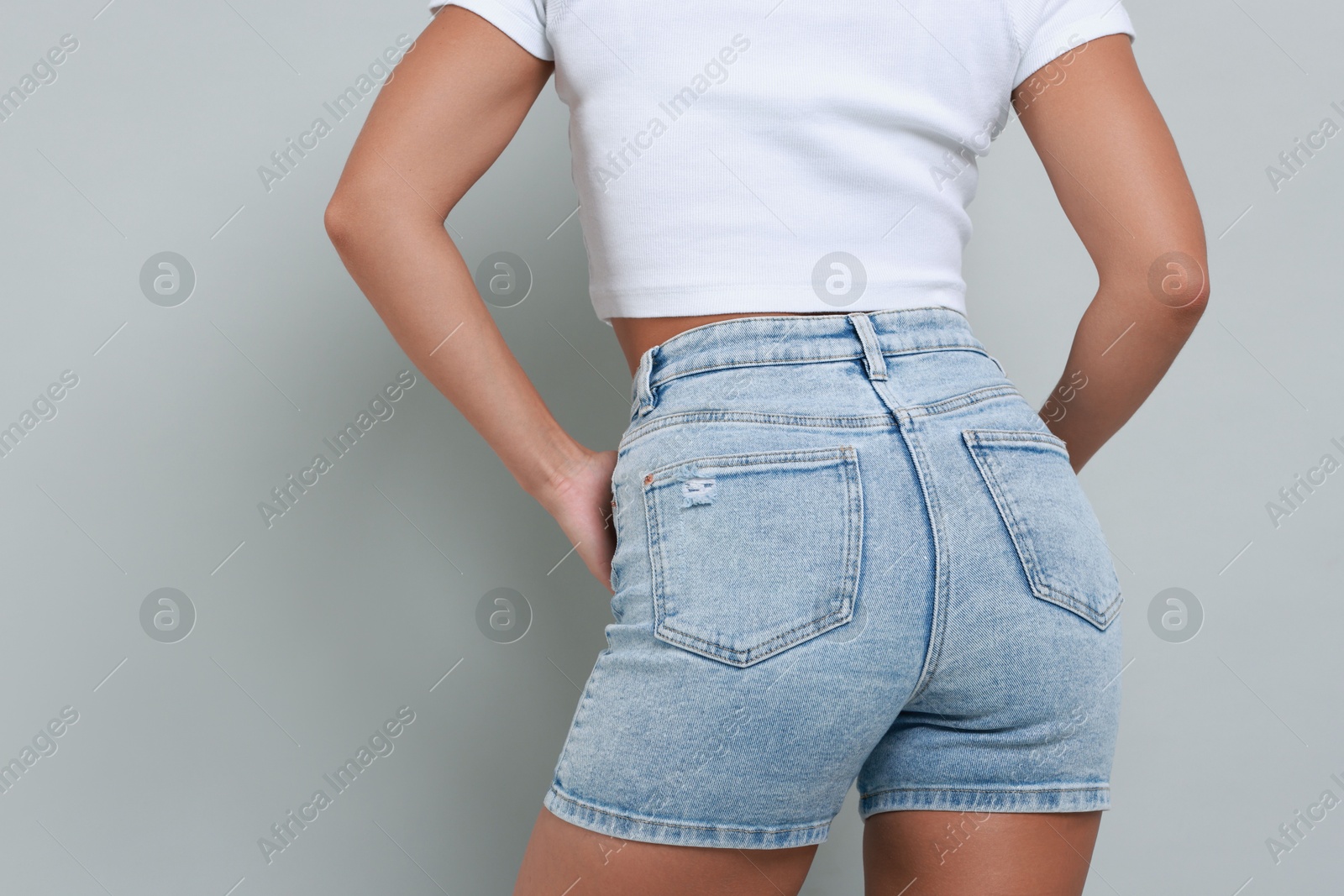 Photo of Woman wearing stylish denim shorts on gray background, closeup