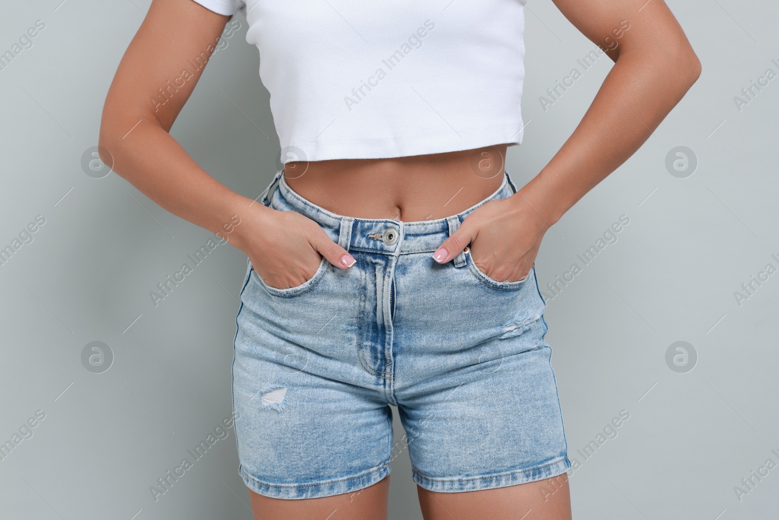 Photo of Woman wearing stylish denim shorts on gray background, closeup