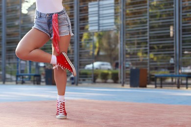 Woman wearing stylish denim shorts outdoors, closeup. Space for text