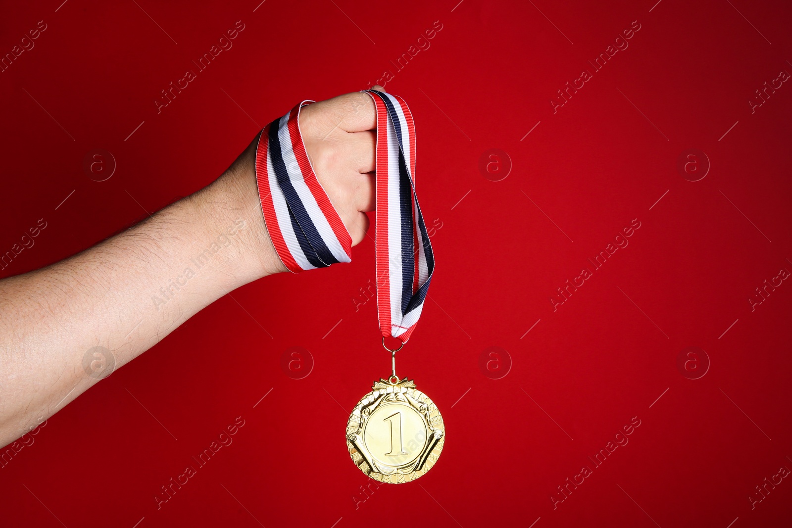 Photo of Man with golden medal on red background, closeup