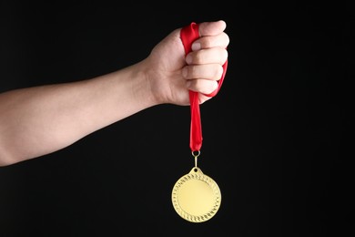 Photo of Man with golden medal on black background, closeup