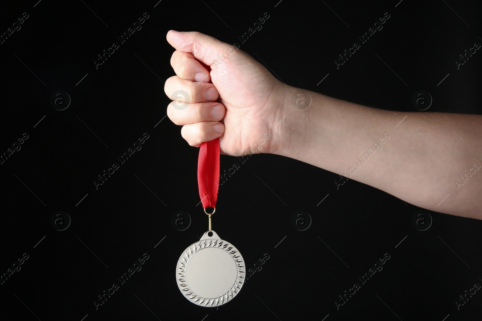 Photo of Man with silver medal on black background, closeup