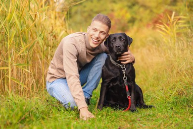 Smiling man with cute dog outdoors on autumn day