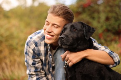 Smiling man with cute dog outdoors on autumn day