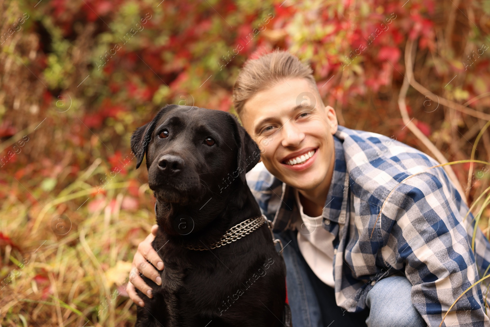 Photo of Smiling man with cute dog outdoors on autumn day