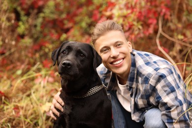 Smiling man with cute dog outdoors on autumn day