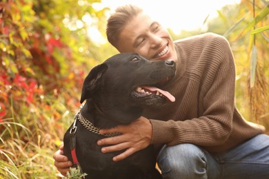 Smiling man with cute dog outdoors on autumn day