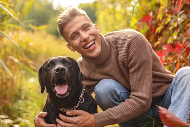 Smiling man with cute dog outdoors on autumn day