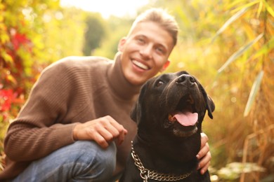 Portrait of cute dog with smiling owner outdoors, selective focus