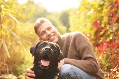 Portrait of cute dog with smiling owner outdoors, selective focus