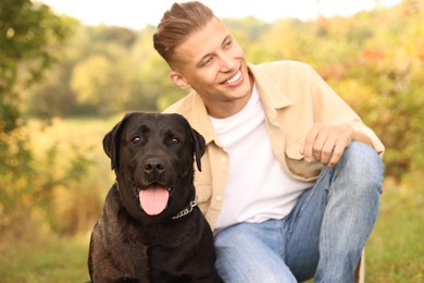 Smiling man with cute dog outdoors on autumn day