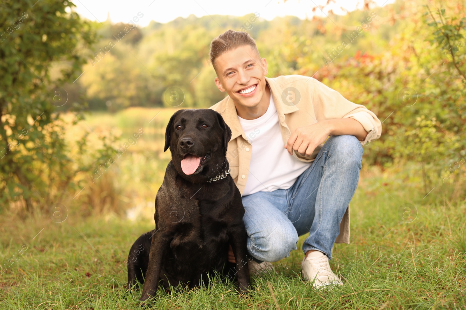 Photo of Smiling man with cute dog outdoors on autumn day