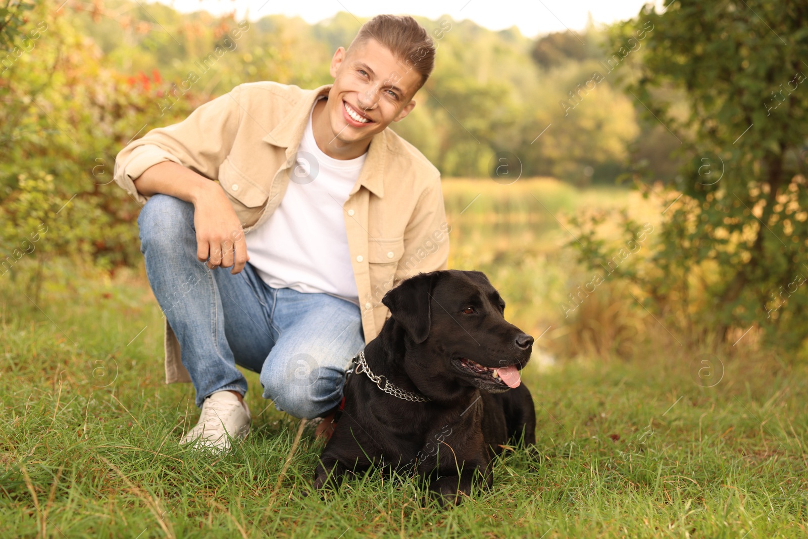 Photo of Smiling man with cute dog outdoors on autumn day